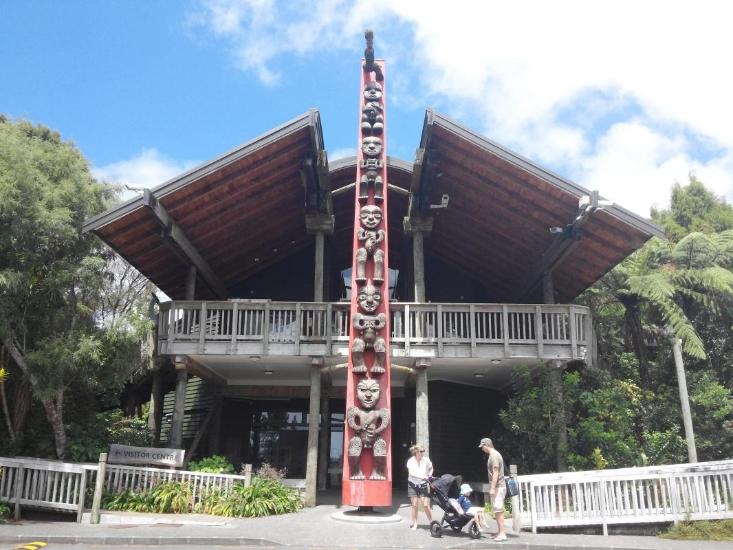 The Arataki Visitor Centre features impressive Māori carvings and panoramic decks overlooking the rainforest